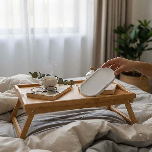 صينية Decorify بيضاوية من الخرسانة المصقولة باللون الأبيض اللامع تستخدم كمنظم أنيق على طاولة سرير خشبية