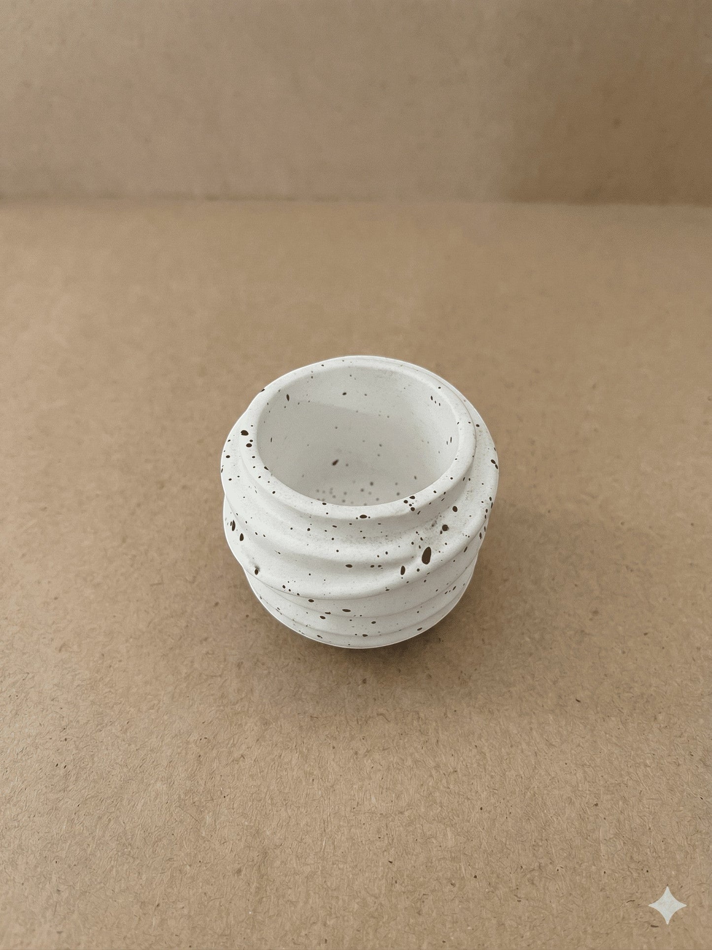 منظم Spiral Jar من Decorify مصنوع من الكونكريت البيضاء اللامعة بنقوش سوداء وتصميم مضلع أنيق لتخزين المجوهرات.
