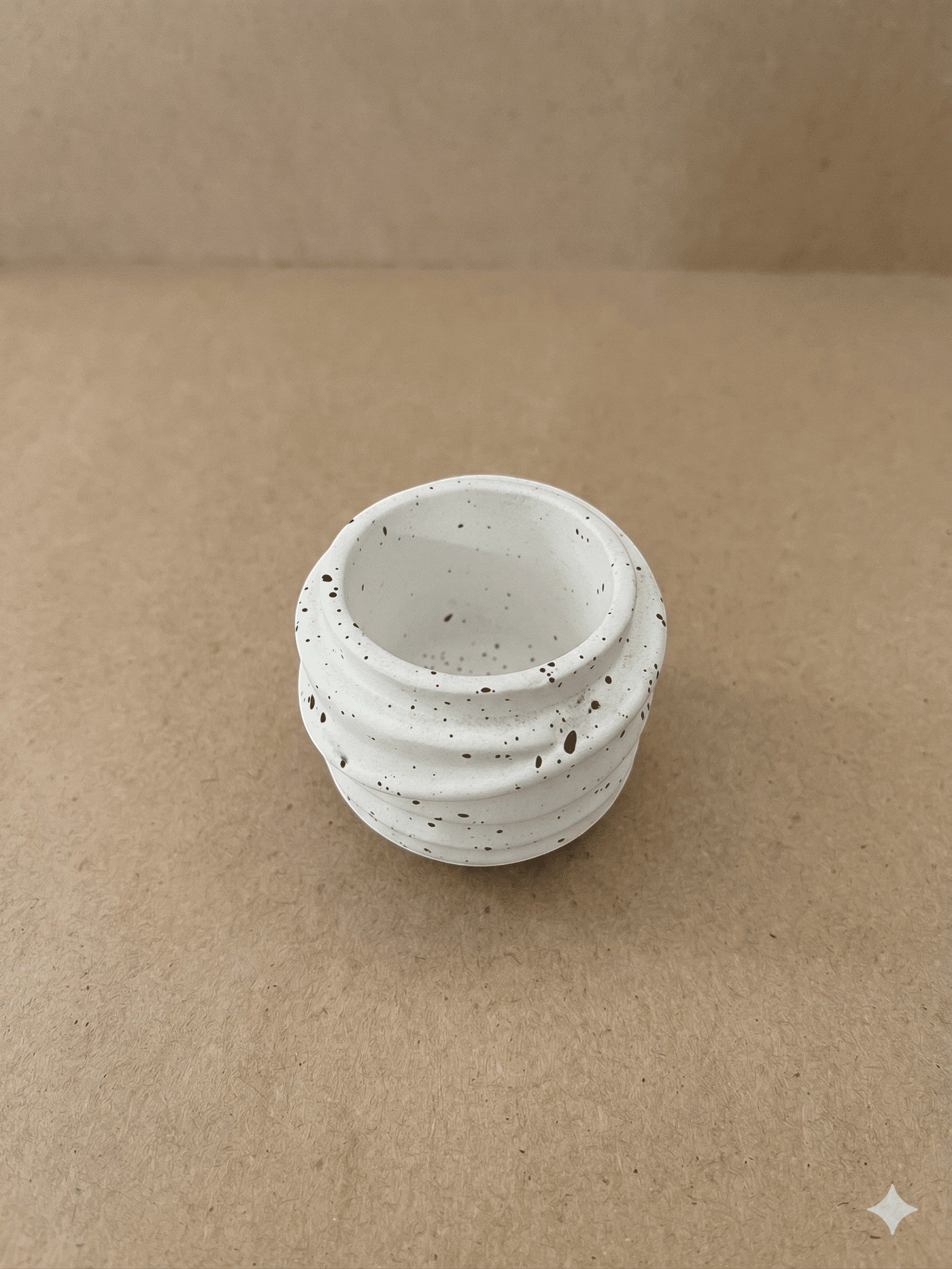 منظم Spiral Jar من Decorify مصنوع من الكونكريت البيضاء اللامعة بنقوش سوداء وتصميم مضلع أنيق لتخزين المجوهرات.